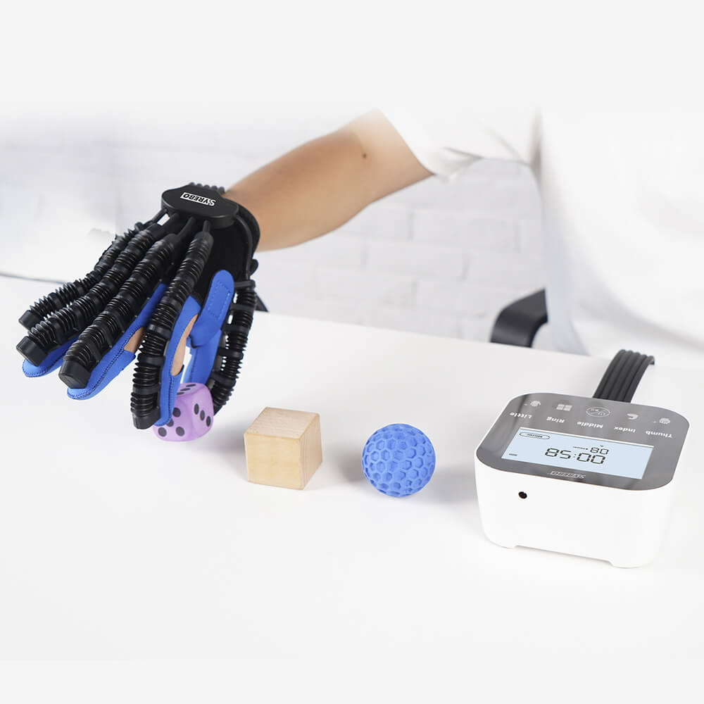 Power glove assisting the hand to pick up a die, a wooden block and a ball next to the C12 control unit